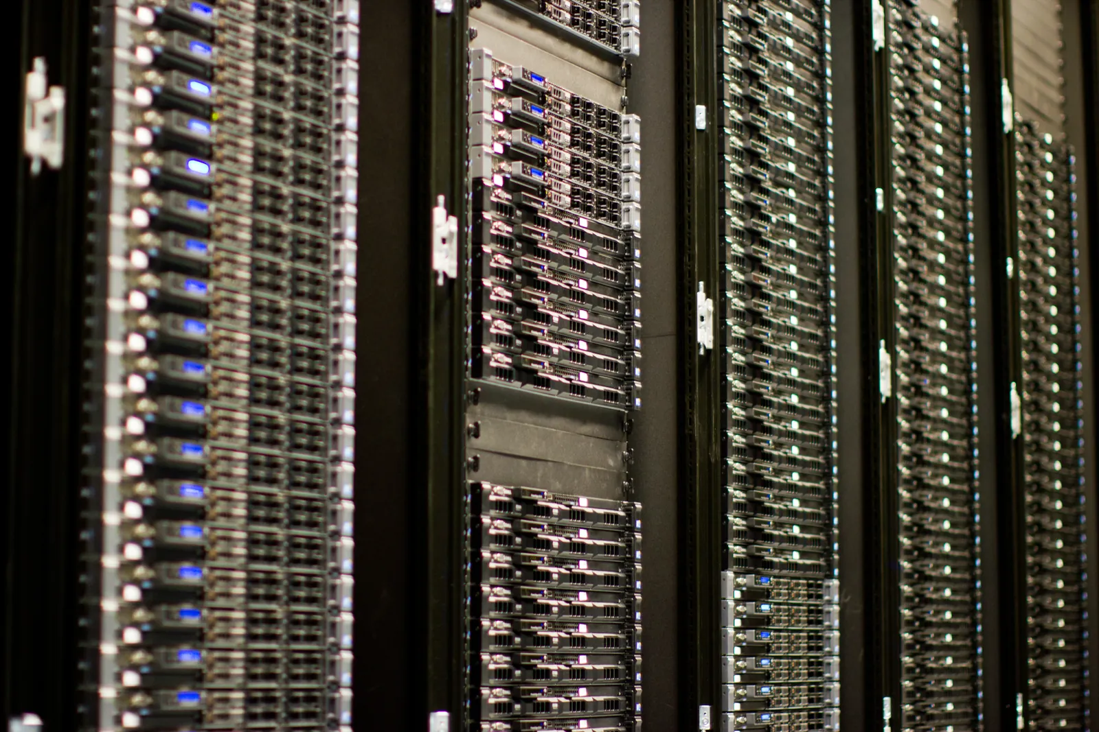 Rows of black server racks filled with 1U servers, their small blue and white status lights receding into the distance